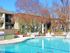 Refreshing swimming pool bordered by pool furniture, grass and autumn trees.