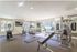 Fitness Center with TV, gym equipment and a yoga mat on the ground.