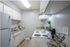 All white kitchen with white appliances and brown speckle countertops.