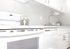 All white kitchen with upper and lower cabinets, with white dishwasher, and a white range.