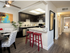 View of the open dining and kitchen area, barstool seating off the light countertop which counter nicely to the dark cabinetry.