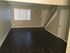 Converge Townhouse living room with dark plank flooring, a window with window covering next to the front door, and the stairway the leads upstairs.