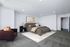 Carpeted bedroom with staged furniture