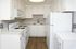 white kitchen with white appliances and vinyl flooring