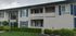 Exterior of building and front office. showcasing the front lawn, shrubbery and trees