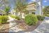 A large evergreen dappling shade across a grassy courtyard in the community.