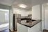 Cypress Cove kitchen featuring a stainless steel stove, stainless steel refrigerator, white cabinets, and black countertops.