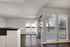Large open living room with natural light streaming in from sliding glass door and large window, wood plank flooring and fireplace are featured