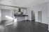 View of living room leading to dining and kitchen area with stainless steel appliances.