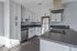 Modern kitchen with stainless appliances and white cabinets.