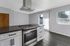 Cooktop with modern oven hood fan extending from ceiling.