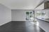 Livingroom with large plank flooring, light grey accent walls and beautiful light coming in from back slider.