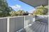 Covered patio with view of tree tops and blue sky.