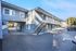 Exterior view of blue two story apartment building.