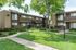 garden style landscaping with light poles and exterior of brown apartment buildings