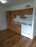 A kitchen in Blacklidge Flats featuring a stove, refrigerator, and cabinets.