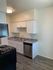 The kitchen at Hedrick Flats features sleek white cabinets and contrasting black appliances.
