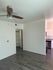 Spacious room with hardwood floors and ceiling fan at Hedrick Flats.