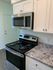 A modern kitchen with sleek stainless steel appliances and elegant granite counter tops at Hedrick Flats.