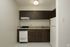 A kitchen with dark wood cabinets, white stove and white fridge.