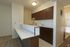 A kitchen with white counter tops and dark wood cabinets