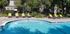 A sparkling blue pool surrounded by lounge chairs, perfect for relaxation and fun in the sun.