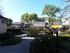 Front of Woodside Apartments leading to leasing office. The community is surrounded by lush greenery.