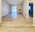 Woodside Apartments' empty room with hardwood floors and a door, offering a blank canvas for personalization.