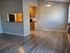 Spacious room with hardwood floors and a ceiling fan in Woodside Apartments.