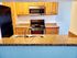 A kitchen with granite countertops and a black refrigerator