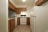 A kitchen with white appliances and wooden cabinets. The Appliances include a stove, fridge and dishwasher.
