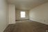 A spacious living room with a window and carpet