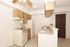 A modern kitchen with white appliances and light wooden cabinets