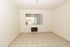 Spacious room with tiled floor and window in The Edison Apartments.