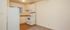 A compact kitchen in La Loma Terrace Apartments featuring a white fridge, microwave, and stove