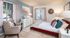 Bedroom with queen bed, dresser, 2 end tables, living chair.