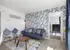 living space with blue accents, blue couch, mid century coffee table with blue curtains