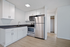 white kitchen with dark countertops and stainless steel appliances