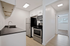 white kitchen with dark countertops and stainless steel appliances