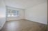 vinyl flooring throughout living room with large wide window next to front door