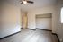 cool toned bedroom with white walls, vinyl flooring and dark baseboards and black accents