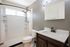 grey walls, white counters, shower with shelving, black finishes