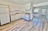 White kitchen countertop with white appliances, and light flooring