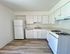 White kitchen countertop with white appliances, and light flooring