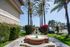 water fountain in middle of walkway with palm trees on each side