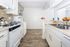 A bright white kitchen featuring a tile backsplash and various decorative elements, creating a clean and inviting atmosphere