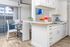 A bright white kitchen featuring a tile backsplash and various decorative elements, creating a clean and inviting atmosphere