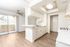 An empty kitchen featuring white cabinetry and vibrant accents, complemented by silver finishes and hardware, creating a fresh and modern space