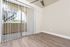 An empty dining room with a sliding glass door that leads to a patio, allowing natural light to fill the space