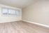 An empty bedroom featuring a long window along the back wall, allowing plenty of natural light to brighten the space